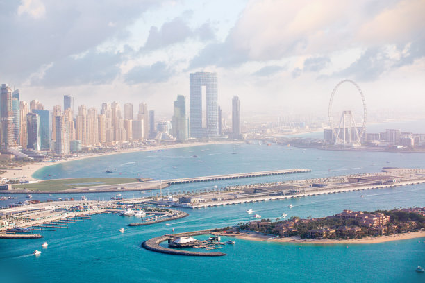 日落时分的阿联酋迪拜码头住宅和办公楼群，以及迪拜眼。海湾水域中的游艇和快艇图片下载