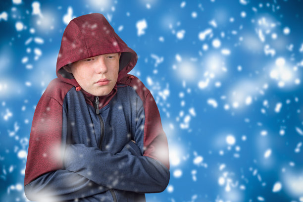 一个穿着卫衣的少年在寒冷中瑟瑟发抖。欧洲经济和能源危机的概念。图片下载