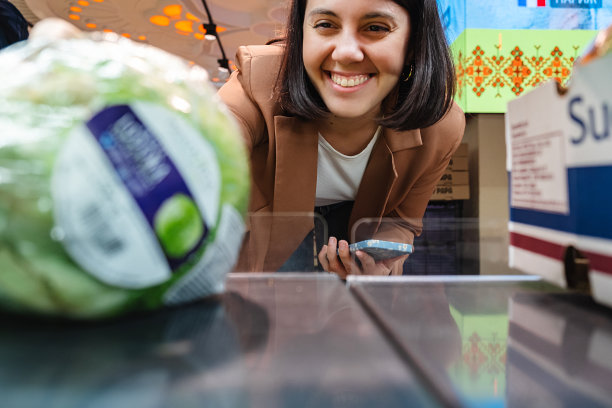 寻找蔬菜的妇女从货架上取下产品一对顾客购物清单图片下载