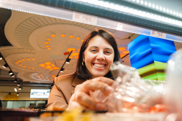 女士寻找货架上的产品夫妇顾客购物清单图片下载