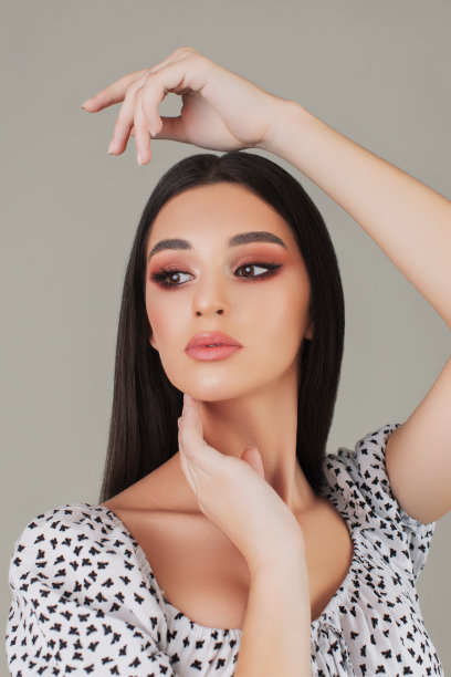 美丽的肖像黑发女孩在灰色背景。裸妆图片下载