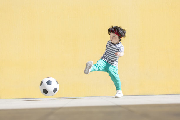 小男孩是一个足球球迷，正在踢足球-库存照片图片下载