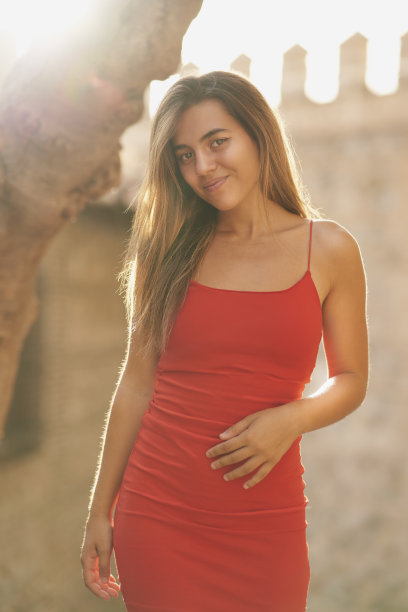 在托莱多，女孩穿着紧身的红色连衣裙和长长的直发图片下载