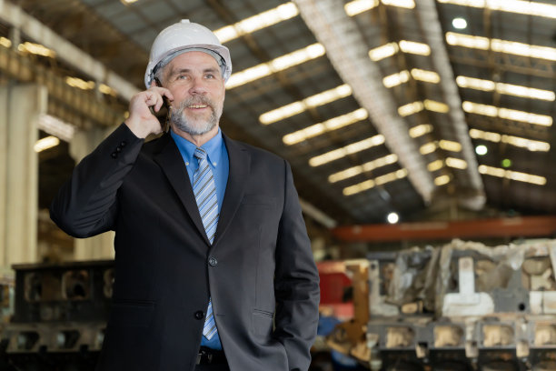 一名商人在一家旧工厂检查现场维修工作，为火车排练做准备。与客户或员工通电话图片下载