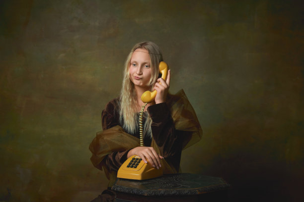 烦恼的年轻女孩长发金发穿中世纪连衣裙像蒙娜丽莎复制品在黑暗的复古背景。复古风格，艺术，时尚，时代概念比较。图片下载