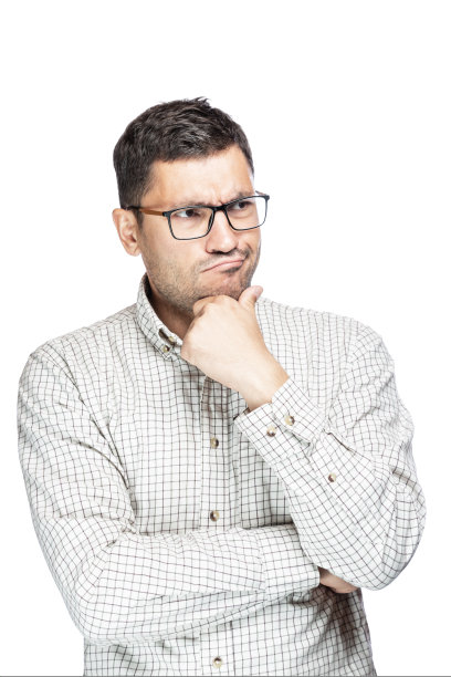 年轻英俊的男子穿着白底格纹衬衫，思考着一个担心的问题，用手托着下巴图片下载