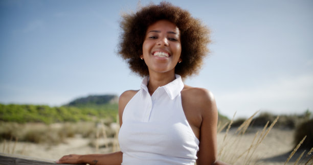 年轻美丽的非洲女孩对着镜头微笑。景观背景。肖像拍摄。图片下载
