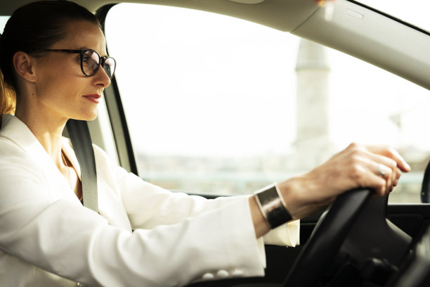 漂亮的女商人开着车。图片下载