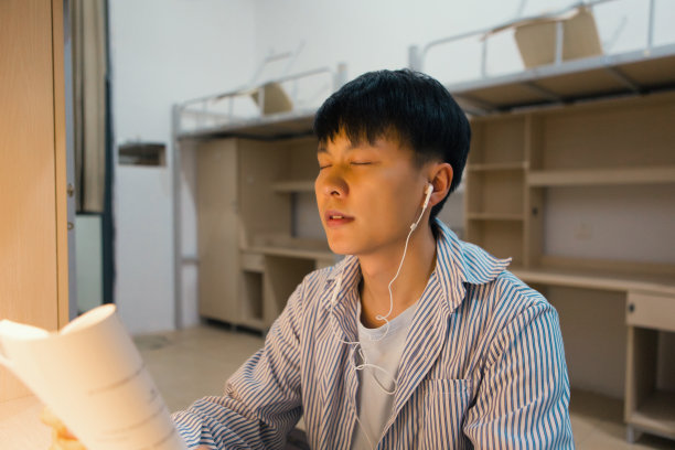 一个大学生在大学宿舍里努力学习图片下载