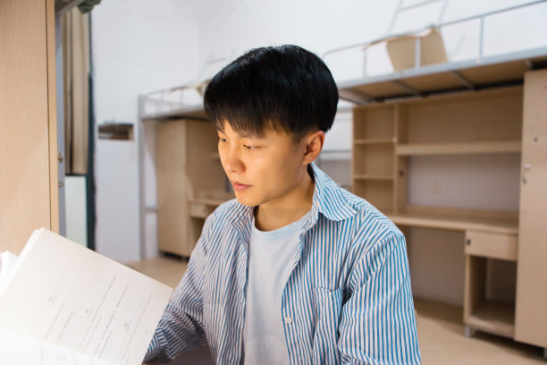 一个大学生在大学宿舍里努力学习图片下载