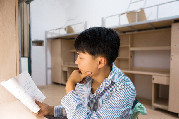 一个大学生在大学宿舍里努力学习图片下载