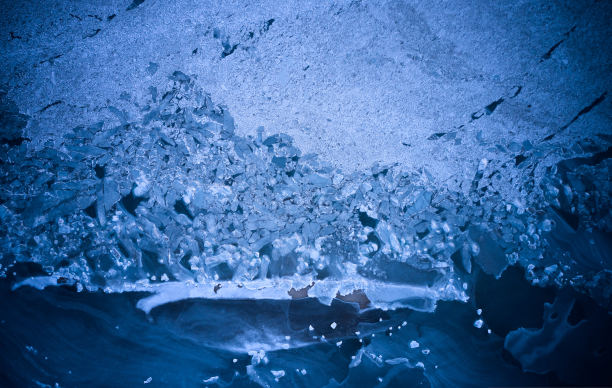 海滩上结冰的冰川的空中鸟瞰图。冬天海洋中破裂的浮冰。全球变暖。海岸线上美丽抽象的冰川图案。生动的蓝色的颜色。图片下载