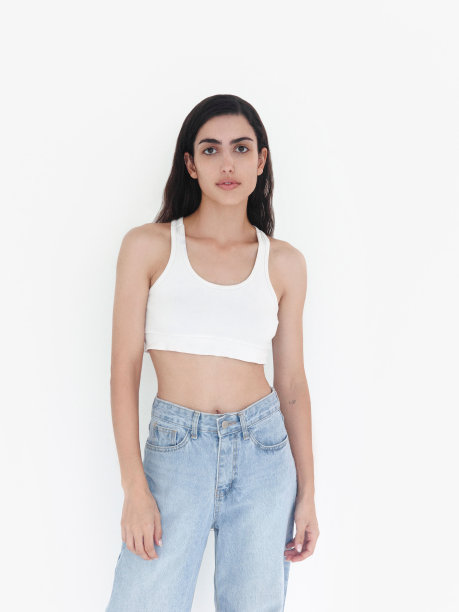 年轻美丽的女人长黑色波浪头发穿白色露脐上衣和蓝色牛仔裤苗条苗条华丽的时装模特工作室肖像图片下载