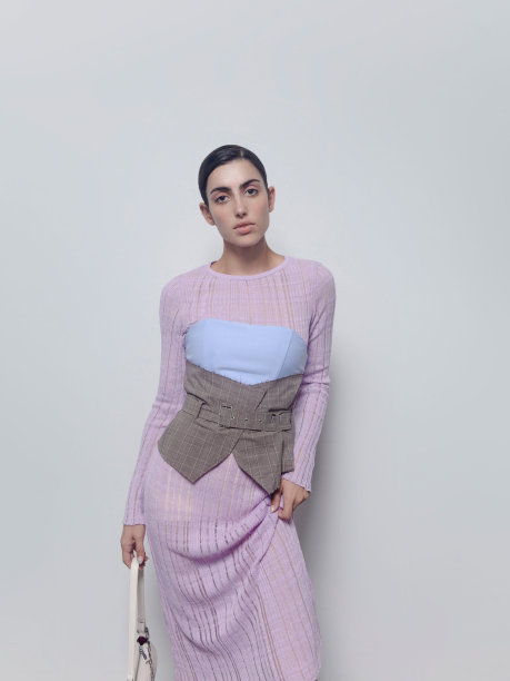 美丽的年轻苗条的女人穿着设计师服装独特的服装从时装系列淡紫色连衣裙紫灰色背心和白色包模型工作室肖像在光背景图片下载