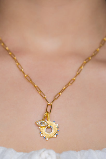 年轻女子脖子上戴着金项链和金耳环。美丽的情人节礼物。图片下载