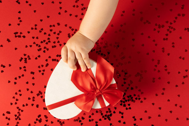 一个孩子伸出手，准备为节日打开一个惊喜。图片下载