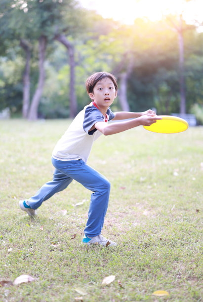 小男孩在公园里玩飞盘图片下载