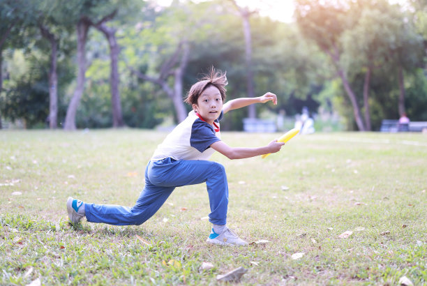 小男孩在公园里玩飞盘图片下载