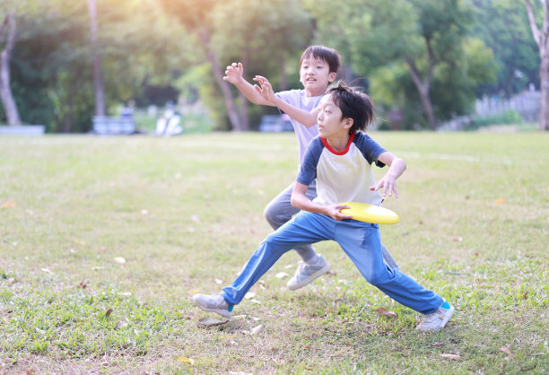 小男孩在公园里玩飞盘图片下载