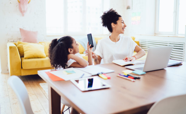 母亲和女儿在做作业时玩得很开心图片下载