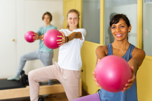 青少年在教练的指导下做普拉提练习图片下载