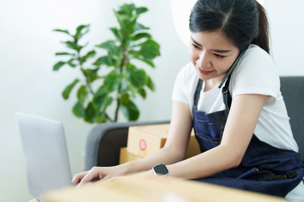 创业创业的独立亚洲女性微笑着用笔记本电脑与欢快成功的网上营销包装盒项目和中小企业送货理念图片下载