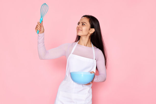 拿着打蛋器和盛着鸡蛋的碗的妇女图片下载