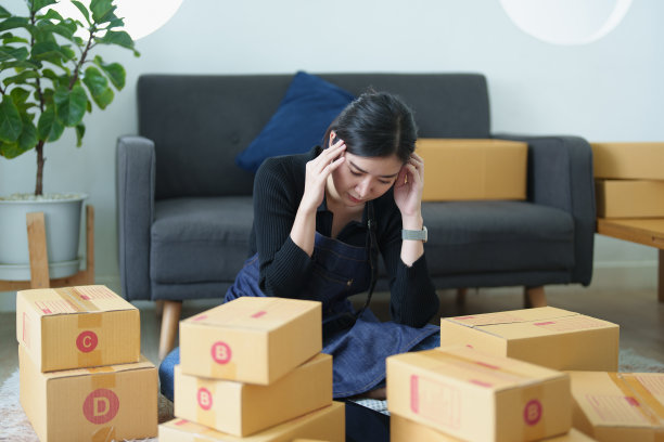 创业小型企业的独立年轻亚洲女性使用不愉快的笔记本电脑不成功的网上营销包装盒项目和中小企业送货的想法。图片下载