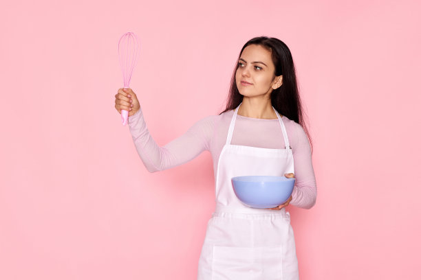 拿着打蛋器和盛着鸡蛋的碗的妇女图片下载