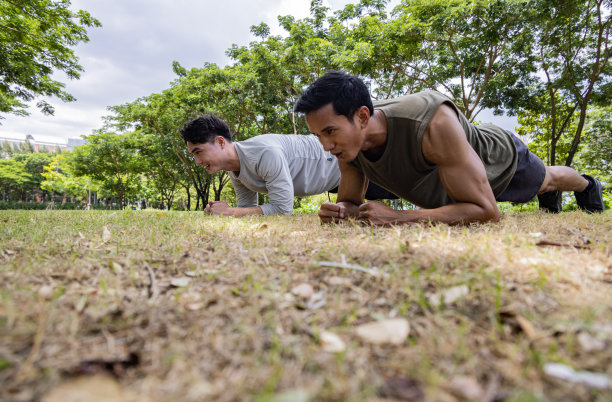 亚洲年轻人一起在绿色公园里趴着。健康的生活方式和户外生活的理念。图片下载