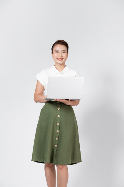 快乐的成年商务女士穿着优雅的衣服看着相机，在白色背景的笔记本电脑上工作图片下载