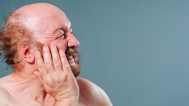 老人抱着他的脸颊，牙疼，胡子，胡子，满脸皱纹，痛苦地扮鬼脸，赤身。图片下载