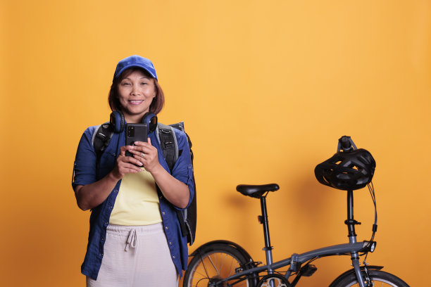 面带微笑的外卖工作人员在现代手机上检查客户地址图片下载