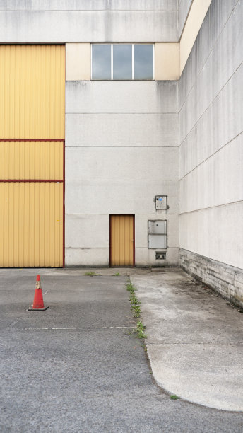 混凝土机库的橙色波纹金属门图片下载