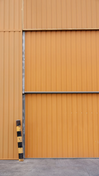 混凝土机库的橙色波纹金属门图片下载