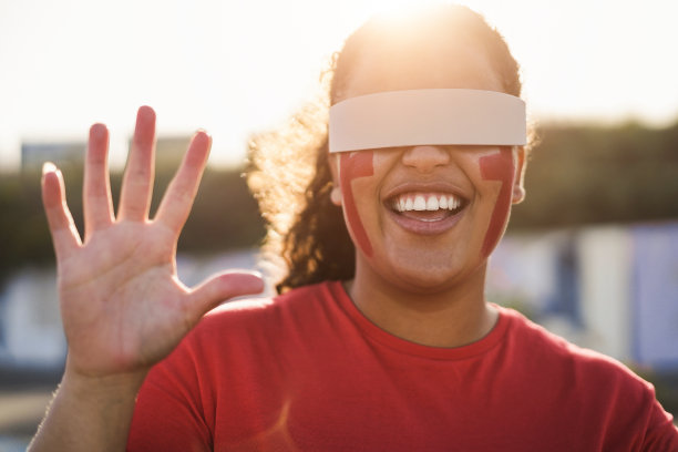 非洲红色体育迷在球场外观看足球比赛时使用未来增强现实眼镜-关注脸图片下载