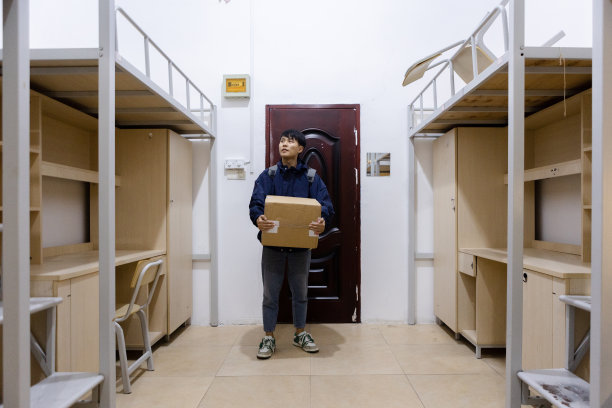 一个男人在学校宿舍里拿着一个包裹图片下载