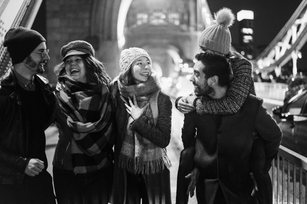 年轻的朋友有乐趣在户外的城市与伦敦塔桥的背景-关注中心女孩的脸-黑白编辑图片下载