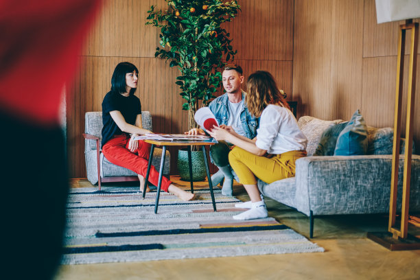 在现代化的阁楼公寓里，白人同事坐在舒适的家具旁的茶几，在头脑风暴会上讨论商业信息，专业人士分析文件图片下载