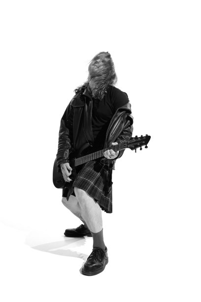 有长发的富有表现力的年轻人的肖像，在白色背景弹奏吉他的摇滚音乐家。黑白摄影图片下载