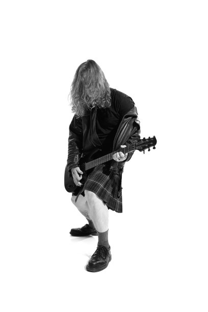 有长发的富有表现力的年轻人的肖像，在白色背景弹奏吉他的摇滚音乐家。黑白摄影图片下载