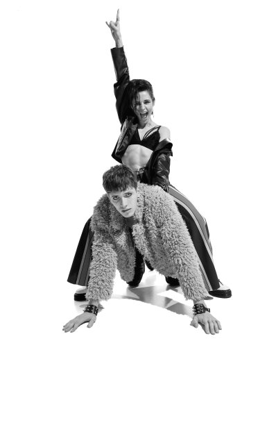 肖像富有表现力的年轻女子穿着奢华的衣服坐在年轻男子的背上。黑白摄影。图片下载