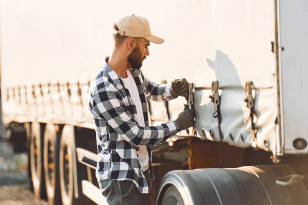 准备出发了。年轻的卡车司机和他的车在白天图片下载