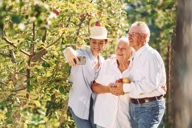 女子正在自拍。女儿和她的老妈妈在一起，爸爸在花园里图片下载