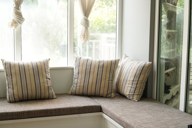 照片显示的是客厅靠窗的沙发床和手工制作的枕头。图片下载