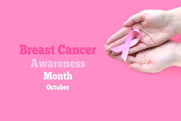 乳腺癌宣传月。成人手持黑色背景的粉色丝带。十月是乳腺癌的国际标志。医学及卫生保健图片下载