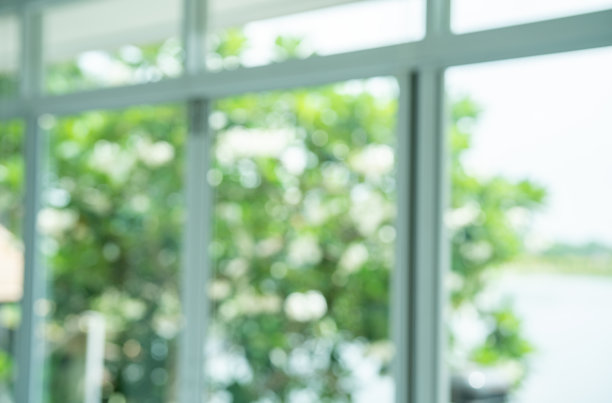 窗口视图与模糊绿色散景光户外自然花园，室内视图面向绿色自然花园模糊背景。图片下载