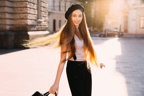 可爱的女孩穿着时髦的衣服对着镜头微笑，在城市广场跳舞图片下载