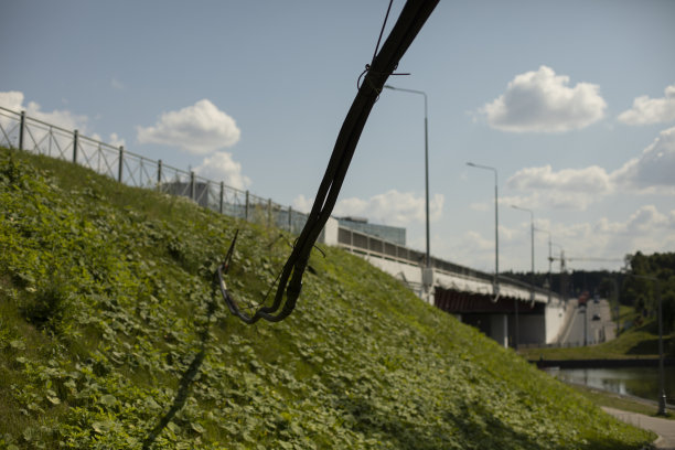高压电线低过道路。黑线延伸到桥上。城市电气线路详细信息。图片下载