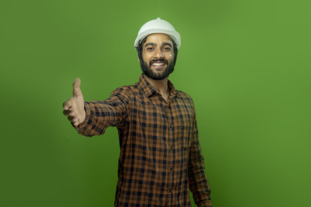 帮助工作的亚洲印度工程师英俊的男人或建筑师在绿色的屏幕白色安全头盔图片下载